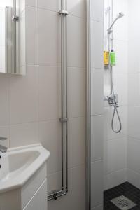 La salle de bains est pourvue d'une douche et d'un lavabo. dans l'établissement FREDA - Relaxing downtown studio, à Helsinki