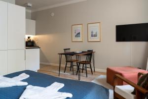 1 dormitorio con cama, mesa y cocina en FREDA - Relaxing downtown studio, en Helsinki