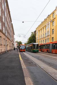 Trois bus sont garés dans une rue à côté des bâtiments dans l'établissement FREDA - Relaxing downtown studio, à Helsinki
