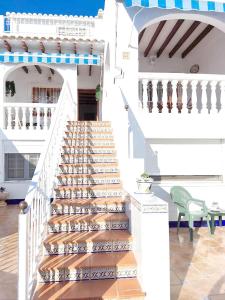 uma escada que leva a uma casa com uma cadeira verde em Apartamento Munay en Playa Albir em Foyes Blanques