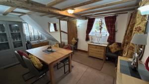 een woonkamer met een houten tafel en stoelen bij 3 Bedroom Character Peak District Farmhouse Near Alton Towers, Polar Bears, Chatsworth House in Cheadle
