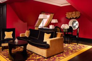 a red living room with a couch and a table at L'oscar London in London