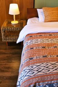 Un dormitorio con una cama y una mesa con una lámpara. en Azami8　202, en Isla Miyako