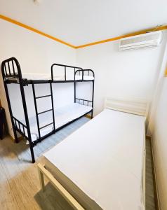 Travelers A Korea Hostel في سول: غرفة صغيرة بها سريرين بطابقين