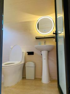 ハノイにあるXuhao Homestayのバスルーム(洗面台、トイレ、鏡付)