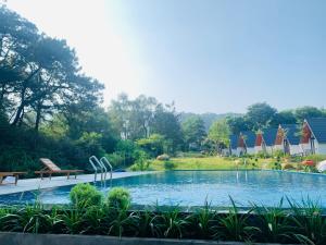 a swimming pool in a yard with chairs and trees at Xuhao Homestay in Thanh Lâm