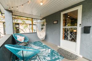 a porch with two blue chairs and a window at Blue Caribou Bungalow in Penticton