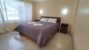 a bedroom with a bed with two towels on it at Villa Cosmopolita in Baños