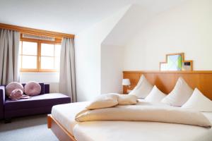 ein Schlafzimmer mit einem großen weißen Bett und einem Fenster in der Unterkunft Relax & Vitalhotel Adler in Schruns-Tschagguns