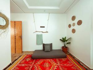 Habitación con cama sobre alfombra roja en DesArt Appartment, en Tamraght Ouzdar