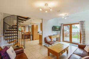 sala de estar con sofá y escalera en Lord Galloway 35 with Hot Tub en Newton Stewart