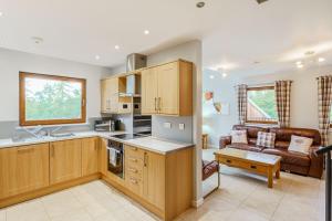 a kitchen and a living room with a couch at Lord Galloway 35 with Hot Tub in Newton Stewart