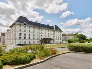 a large white building with a black roof at B&B HOTEL près de Disneyland Paris in Magny-le-Hongre