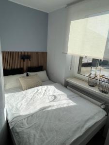 1 cama blanca en un dormitorio con ventana en Ferienwohnung Basaltliebe Mendig, en Mendig