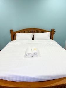 Una cama con dos toallas blancas encima. en บ้านชมฟ้า - Bann Chomfah Resort & Cafe 
