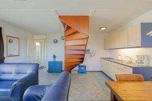 uma cozinha com uma escada em espiral numa sala de estar em Vakantiehuis Guja - Callantsoog em Callantsoog
