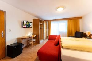 a hotel room with a bed and a red couch at Gästehaus -Pension Edelweiss in Vent