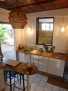 uma cozinha com uma mesa, um lavatório e uma janela em MANGOBELO entre océan et rivières em Capesterre-Belle-Eau