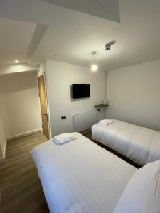 um quarto de hotel com duas camas e uma televisão de ecrã plano em The Dormy House em Tenby