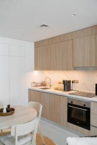 uma cozinha com uma mesa, um lavatório e um fogão em Clever Guest Beach Vista 1 no Dubai