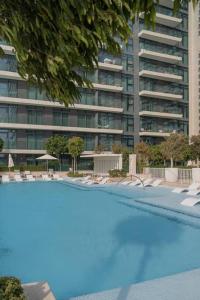 una grande piscina di fronte a un alto edificio di Clever Guest Beach Vista 1 a Dubai