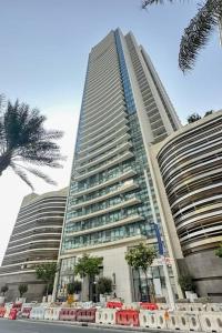 a tall building with trees in front of it at Clever Guest Beach Vista 1 in Dubai