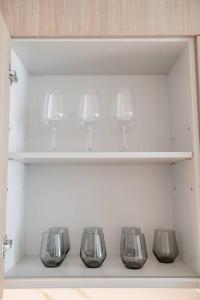 una fila di bicchieri da vino seduti su uno scaffale di Clever Guest Beach Vista 1 a Dubai