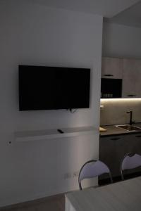 una TV a schermo piatto appesa a un muro in cucina di Al Mare da Carlo a Civitanova Marche