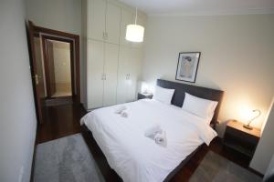 een slaapkamer met een groot wit bed en 2 handdoeken bij LIDA'S APARTMENT LAKE VIEW in Kastoria