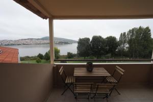 a table and chairs on a balcony with a view of a lake at LIDA'S APARTMENT LAKE VIEW in Kastoria