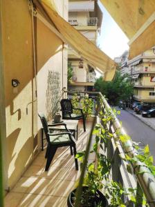 a balcony with two chairs and a table and some plants at Casa Luna in Thessaloniki