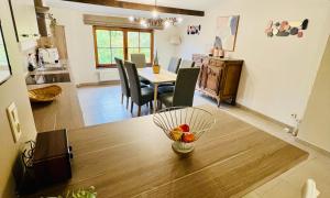 a kitchen and dining room with a bowl of fruit on a table at Appartement au cœur de Rochefort in Rochefort