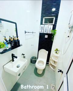 a bathroom with a white toilet and a sink at Tulip Hijau Bukit Beruntung in Rawang