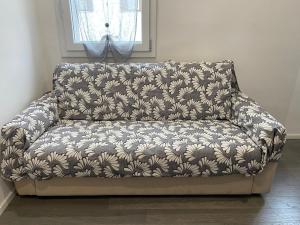 a couch sitting in a living room with a flower pattern at Momy's House in San Donà di Piave