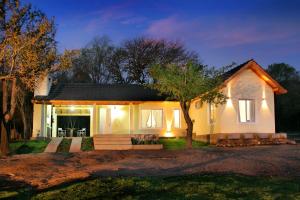 a small white house with lights on at La Faustina Casas de Campo in Villa General Belgrano