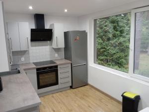 a kitchen with a stainless steel refrigerator and a window at Ośrodek Wypoczynkowy Zakątek in Kąty Rybackie