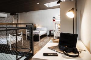 Habitación con escritorio, ordenador portátil y cama en room00 Chueca Hostel en Madrid