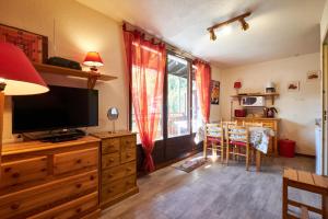 a living room with a television on a wooden dresser at 2 Alpes - appartement 2-4 pers in Les Deux Alpes