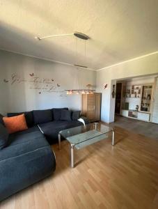 a living room with a blue couch and a glass table at Ferienwohnung in Ehrenfriedersdorf in Ehrenfriedersdorf