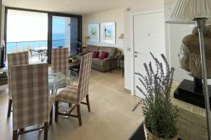 Un comedor y una sala de estar con mesa y sillas. en Luxury Apartment/ Sea views/Pool/Gym, en San Jorge