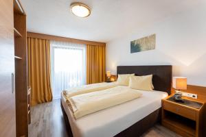 a bedroom with a large bed and a window at Gästehaus -Pension Edelweiss in Vent