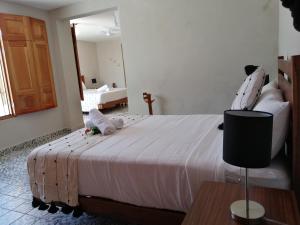 - une chambre avec un grand lit blanc dans l'établissement Hotel Casa Piedad, à Campeche