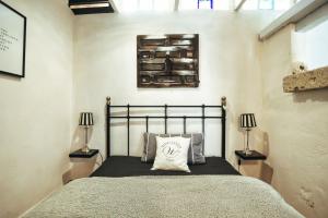 een slaapkamer met een bed met twee lampen aan de muur bij Finca Vino Tinto 5s in Icod de los Vinos