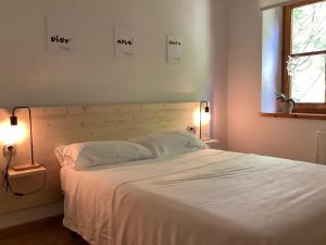 1 dormitorio con 1 cama blanca grande y 2 lámparas en P06 Dellui By Immovall, en Pla de l'Ermita