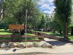 a wooden sign in a park with rocks and trees at P06 Dellui By Immovall in Pla de l'Ermita
