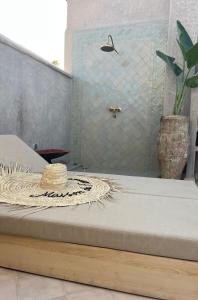 a straw hat sitting on a bed in a bathroom at Riad des Fragrances dar el Bacha in Marrakech +81 photos