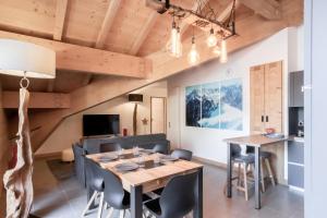 een eetkamer en een woonkamer met een houten tafel en stoelen bij Terra Losa 2 - Quiet and modern apartment - City center in Les Houches