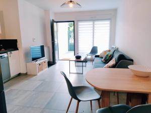 a living room with a couch and a table at Le Moulin du Lac, Terrasse, Neuf in Saint-Paul-lès-Dax