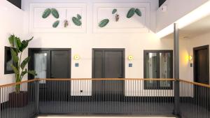 una fila di porte nere con foglie verdi sul muro di Casa Alhaja by Shiadu a Siviglia