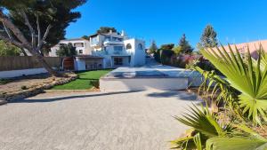 une grande maison blanche avec une allée dans l'établissement Maison d'architecte vue mer, à Carry-le-Rouet